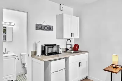 a kitchen with white cabinets and a sink and a microwave at Young Circle & Hollywood Blvd Posh Studio Suite in Hollywood