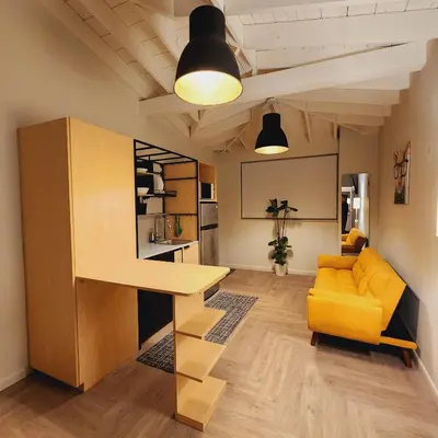 a living room with a yellow couch and a table at Private Home Studio Central Located in Miami 1 in Opa-locka