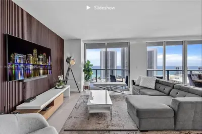 a living room with a couch and a tv at Apartment 3B/3B Stunning view of the intercostal in Hallandale Beach