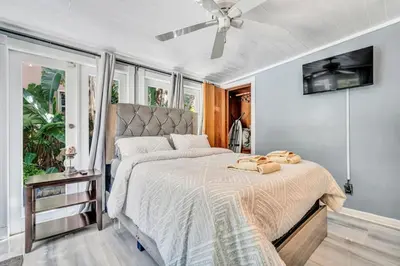 a bedroom with a large bed with a ceiling fan at Family Escape 2BR Main plus 1BR Cottage Heated Pool in Fort Lauderdale