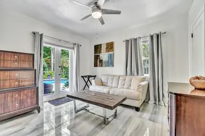 a living room with a couch and a table at Family Escape 2BR Main plus 1BR Cottage Heated Pool in Fort Lauderdale
