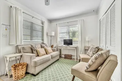 a living room with a couch and a desk with a computer at Family Escape 2BR Main plus 1BR Cottage Heated Pool in Fort Lauderdale