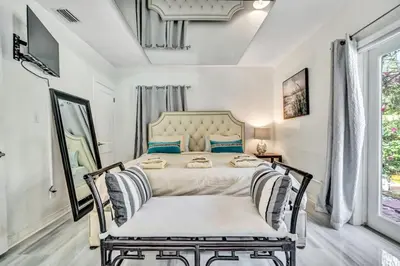 a bedroom with a large bed with blue pillows at Family Escape 2BR Main plus 1BR Cottage Heated Pool in Fort Lauderdale