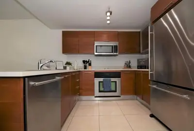 a kitchen with wooden cabinets and stainless steel appliances at Lovely Midblock building 1 bedroom 1 bathroom apartment in Miami