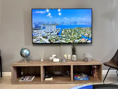 a living room with a tv on a wall at Lovely Midblock building 1 bedroom 1 bathroom apartment in Miami