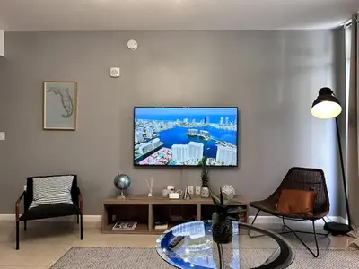 a living room with a flat screen tv on a wall at Lovely Midblock building 1 bedroom 1 bathroom apartment in Miami