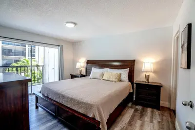 a bedroom with a bed and a balcony at Le Cartier Apartments Sunny Isles in Sunny Isles Beach