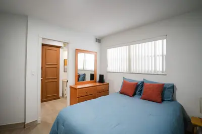 a bedroom with a blue bed and a mirror at Le Cartier Apartments Sunny Isles in Sunny Isles Beach