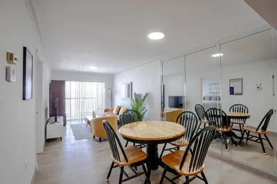 a dining room and living room with a table and chairs at Le Cartier Apartments Sunny Isles in Sunny Isles Beach