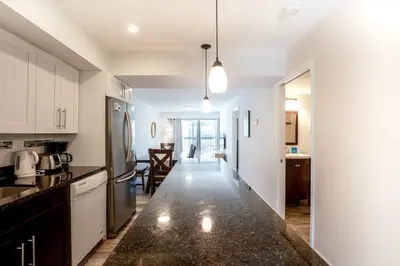 a kitchen with white cabinets and a black counter top at Le Cartier Apartments Sunny Isles in Sunny Isles Beach