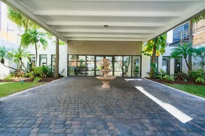 a building with a fountain in the middle of a driveway at Le Cartier Apartments Sunny Isles in Sunny Isles Beach