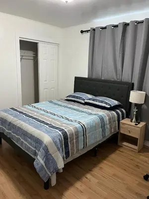 a bedroom with a bed with a blue and white blanket at Edercozy in Miami