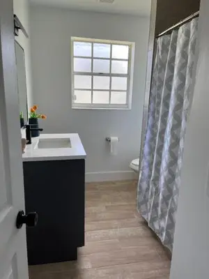 a bathroom with a sink and a toilet and a window at Edercozy in Miami