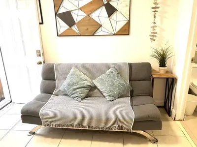 a couch with three pillows on it in a living room at Cozy and sweet home in Miami