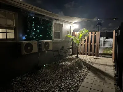 a house with a table and chairs outside at night at Cozy and sweet home in Miami