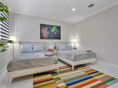 a bedroom with two beds and a colorful rug at Villa ART Pool Golf Volleyball in Miami