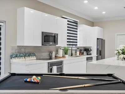 a kitchen with a pool table with two bats at Villa ART Pool Golf Volleyball in Miami