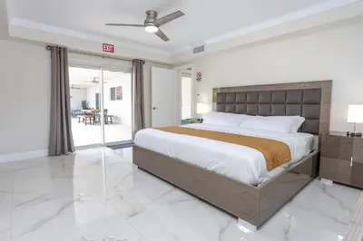 a bedroom with a large bed and a balcony at Amazing 5BR Villa Heated Pool near Hard Rock in Hollywood