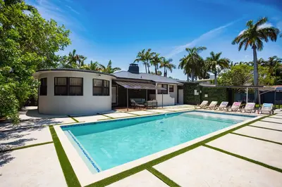 a swimming pool in front of a house with palm trees at Luxury Villa WALK 5 minutes to Hollywood Beach in Hollywood