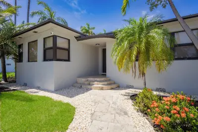 a house with a palm tree in front of it at Luxury Villa WALK 5 minutes to Hollywood Beach in Hollywood