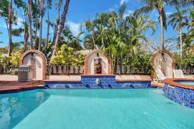a swimming pool with a resort style house with palm trees at Magnificent Villa by Lake near Hollywood Beach in Hollywood
