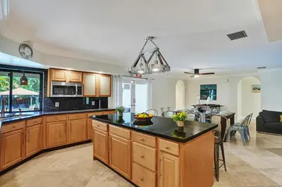 a kitchen with wooden cabinets and a island in a room at Magnificent Villa by Lake near Hollywood Beach in Hollywood