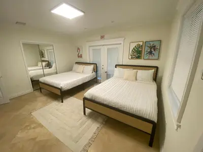 a bedroom with two beds and a mirror at Entire home in Biscayne Park, Florida in Biscayne Park