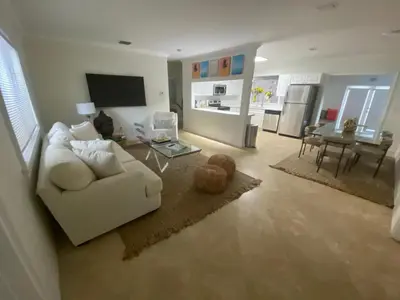 a living room with a white couch and a table at Entire home in Biscayne Park, Florida in Biscayne Park