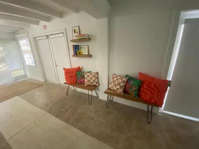 a living room with two benches with colorful pillows at Entire home in Biscayne Park, Florida in Biscayne Park