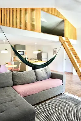 a living room with a couch with a hammock on it at New Nordic Touch Loft, Central Location in Miami