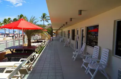 a patio with chairs and tables and an umbrella at Diane Oceanfront Suites in Hollywood
