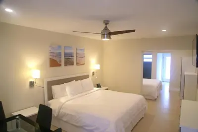 a bedroom with two beds and a ceiling fan at Diane Oceanfront Suites in Hollywood