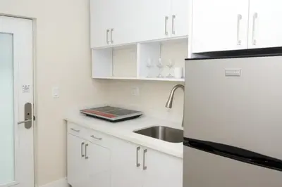 a white kitchen with a sink and a refrigerator at Diane Oceanfront Suites in Hollywood