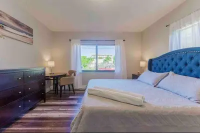 a bedroom with a blue bed with a desk and a window at Charming house Miami in Miami