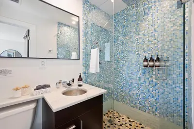 a bathroom with a sink and a shower with blue tiles at Waterfront - Kayak & Paddleboards - Firepit - Pool in Miami