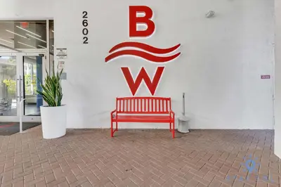a red bench sitting in front of a w sign at Spectacular Apartment Beachwalk Bliss Pool Gym in Hallandale Beach