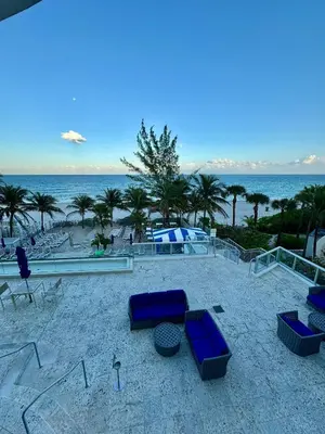 a beach with blue lounge chairs and the ocean at Marena Resort in Sunny Isles Beach
