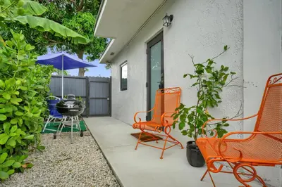 a patio with orange chairs and a grill at Suite Azul Miami - Private Guest Suite with Patio, Free Parking, Near Wynwood and Beaches in Miami