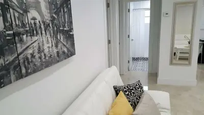 a white living room with a white couch and a painting at N61 in Hollywood
