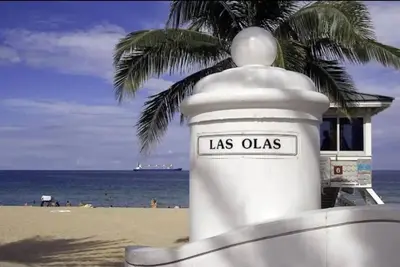 a white lighthouse on the beach with a palm tree at King Bed, 3 miles to Stadium in Miami Gardens