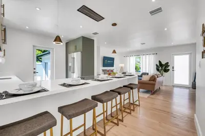 a kitchen and living room with a bar with stools at Samadhi - NEW 15 min drive to Ultra, by Newman Hospitality in Miami Shores