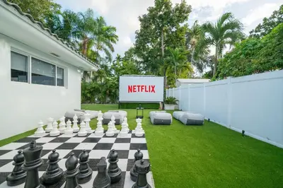 a backyard with a chessboard and a sign that reads netflix at New Luxury Villa Delilah Biscayne Park in Biscayne Park