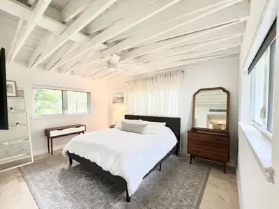 a white bedroom with a bed and a mirror at Pool! Best location! Steps to the water! Kid friendly! in Miami