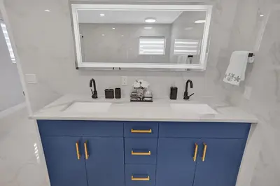 a bathroom with a sink and a mirror at Modern 4 Bedroom -Kosher - Heated Pool - Game Room in Hollywood
