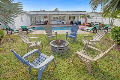 a group of chairs sitting around a fire pit at Modern 4 Bedroom -Kosher - Heated Pool - Game Room in Hollywood