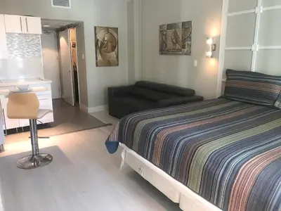 a bedroom with a bed and a couch at Oceanfront Miami Beach Studio 925 in Miami Beach
