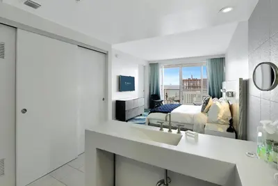 a hotel room with a sink and a bedroom at Nautica - Ocean View & Rooftop Pools! by Newman Hospitality in Fort Lauderdale
