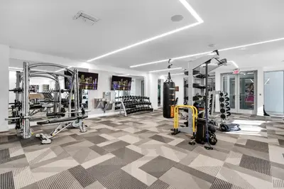 a gym with treadmills and machines in a room at Miami Magic Vibrant 2 Bedroom with Free Parking in Miami