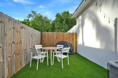 a patio with a table and chairs and a fence at Villa 2 in Miami in Miami