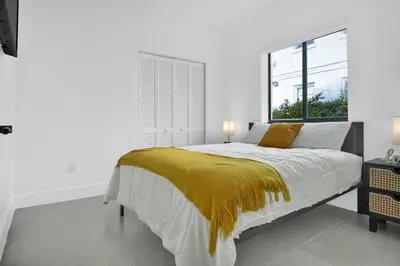 a bedroom with a bed with a yellow blanket on it at Villa 2 in Miami in Miami